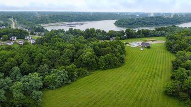 A lush green landscape with a large lake, surrounded by dense forests and residential houses.