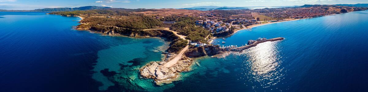 Church and sea with beach and mountains in Nea Roda