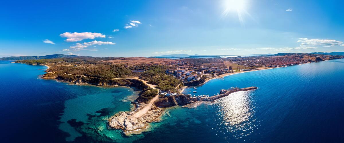 Church and sea with beach and mountains in Nea Roda