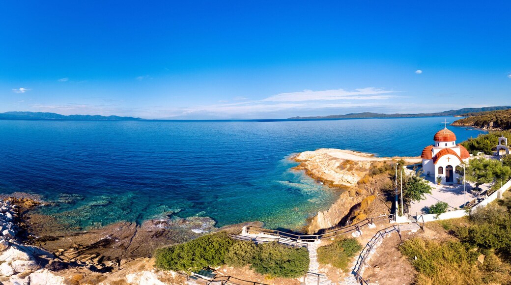 Church and sea with beach and mountains in Nea Roda