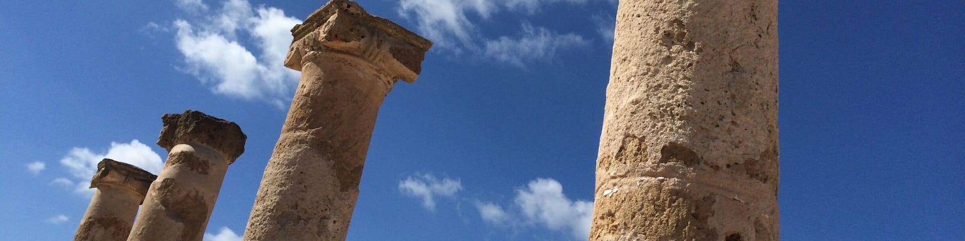 Ancient stone columns against a clear blue sky.