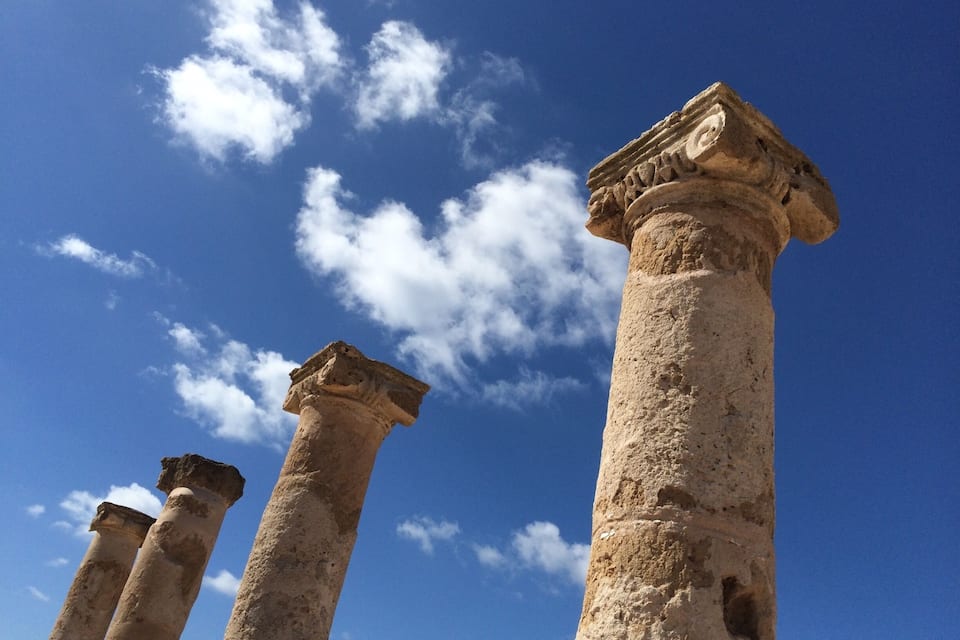 Ancient stone columns against a clear blue sky.
