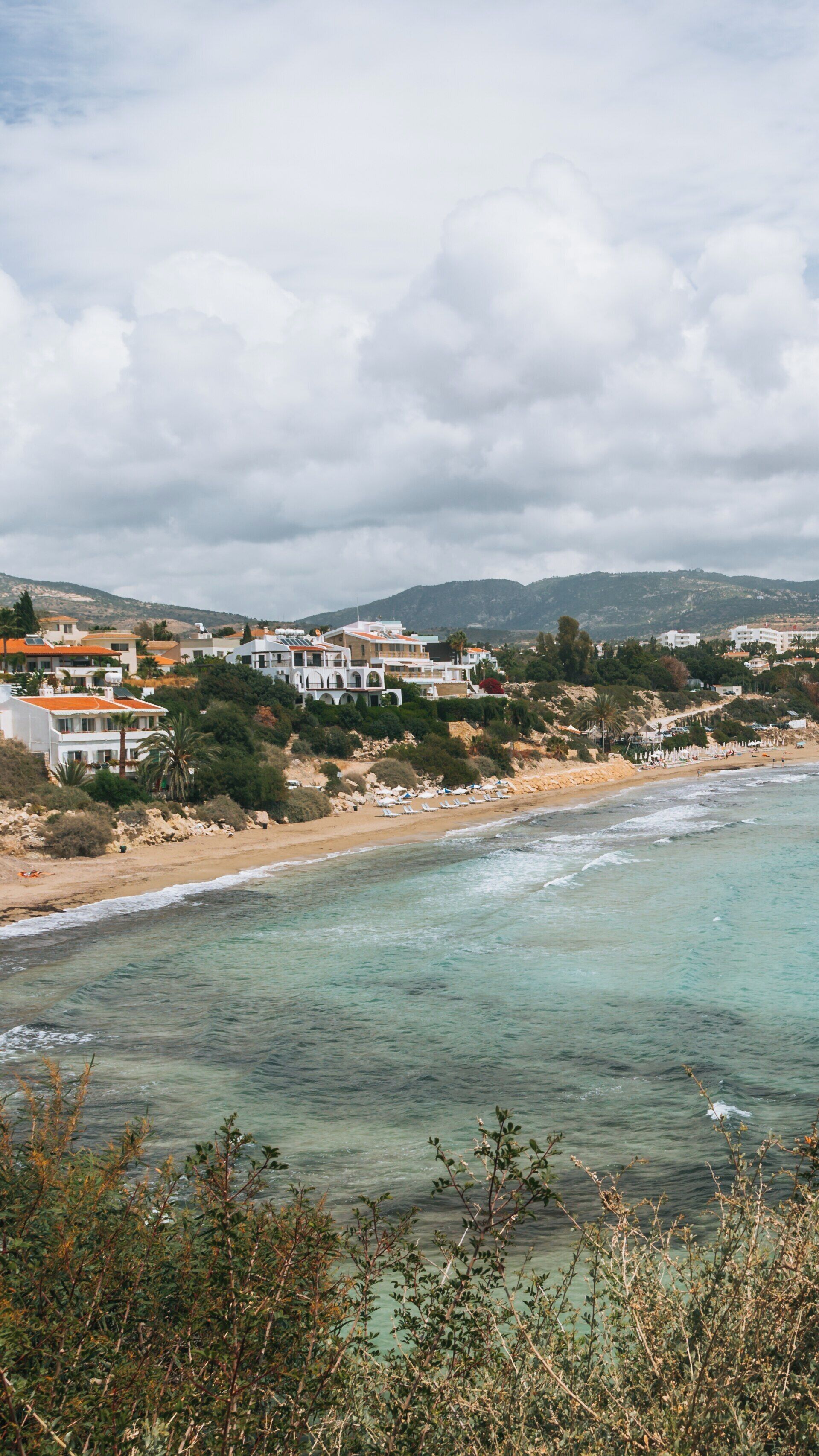Beautiful Coral Bay Beach with Crystal Clear Waters and Scenic Cliffs in Pegeia Cyprus on a Cloudy Day