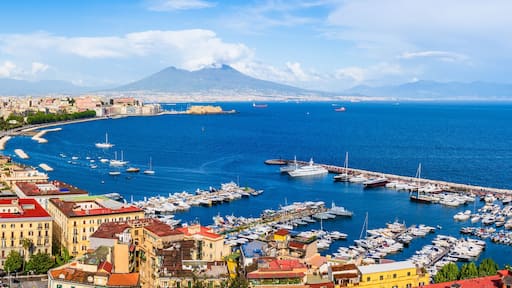 Naples city and port with Mount Vesuvius on the horizon seen from the hills of Posilipo. Seaside landscape of the city harbor and golf on the Tyrrhenian Sea
