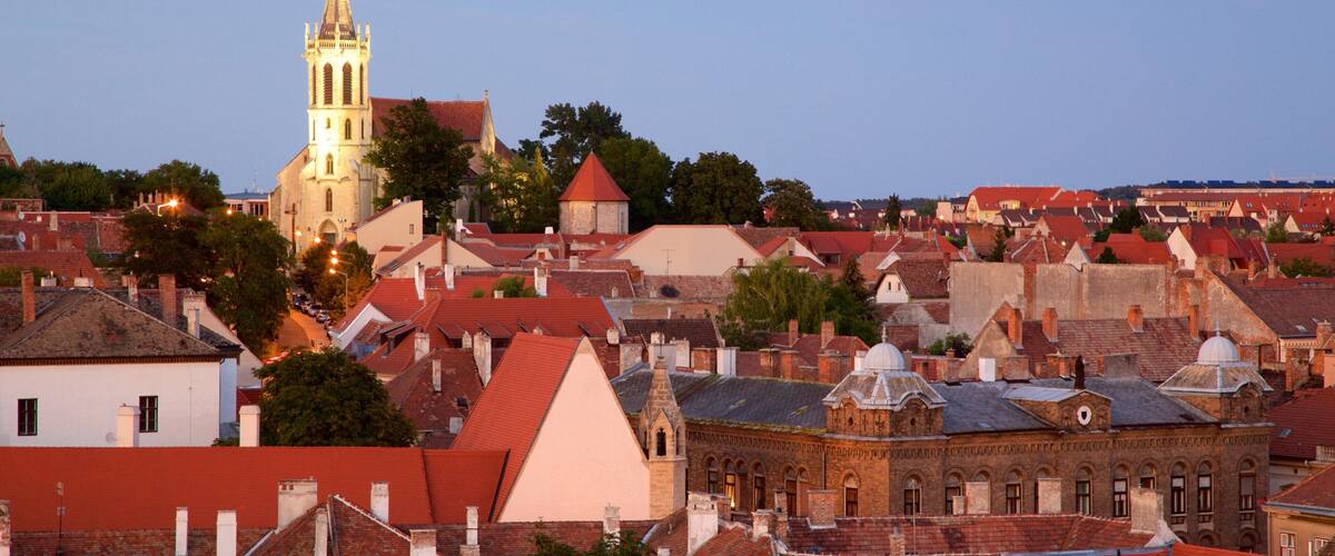 A historic town with a prominent church tower, red-roofed buildings, and a mix of architectural styles.