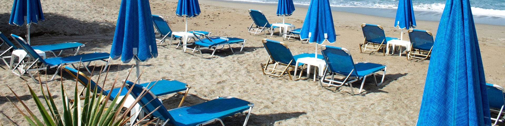 Crete island, Greece Agia Marina beach near Chania Parasols and sun loungers on the sands