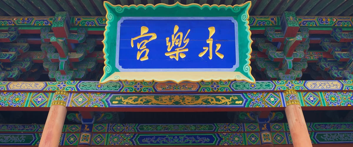 A traditional Chinese building with ornate roof tiles and colorful patterns.