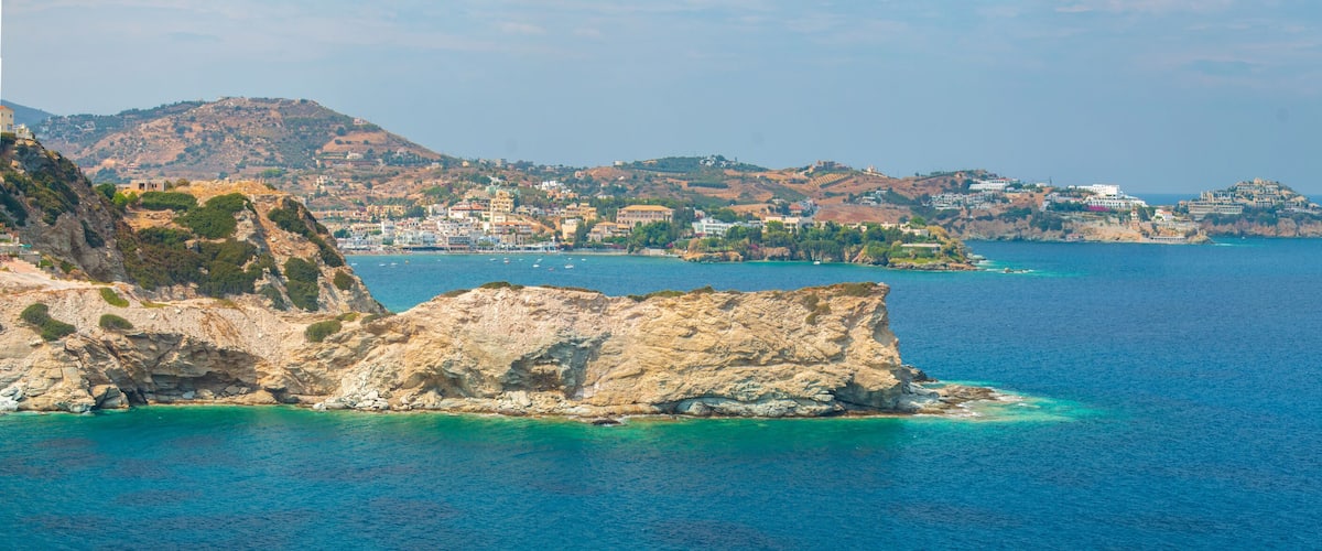 A coastal town with rocky cliffs and a clear blue sea.