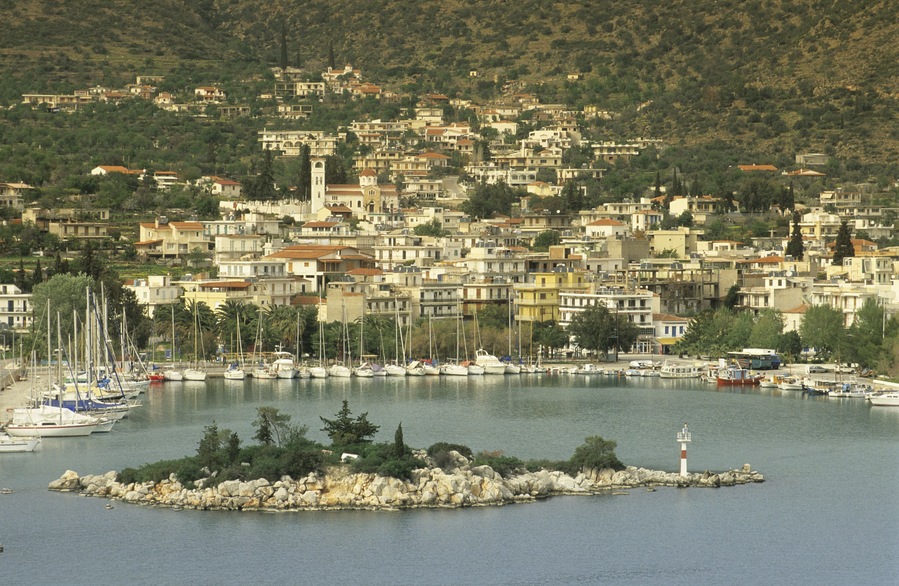 A coastal town with a marina, boats, and a lighthouse.
