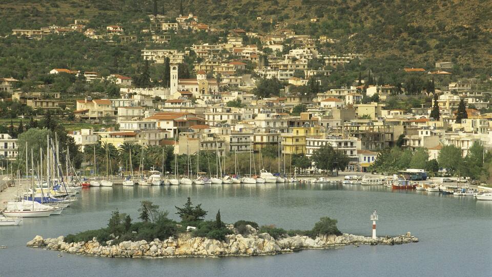 A coastal town with a marina, boats, and a lighthouse.
