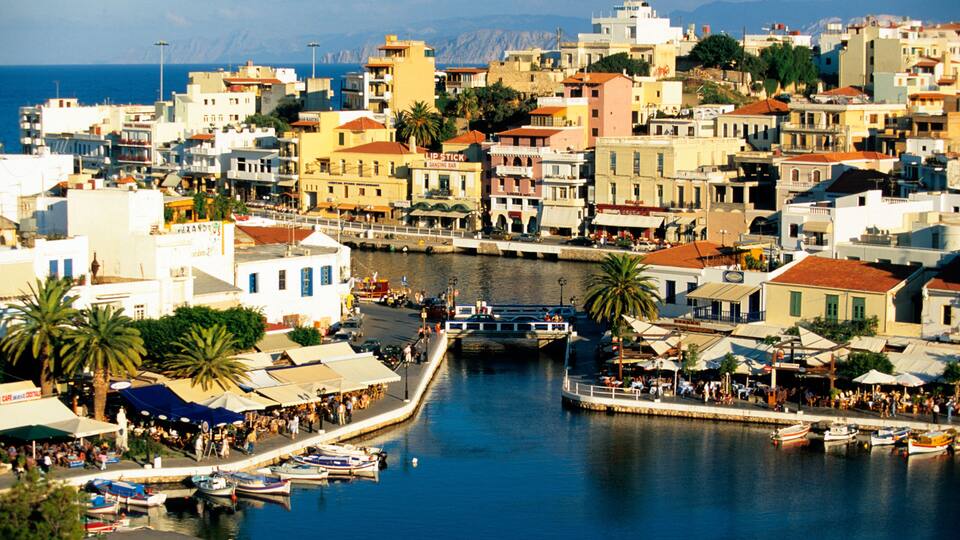 A coastal town with a harbor, boats, and a densely packed urban area with colorful buildings.