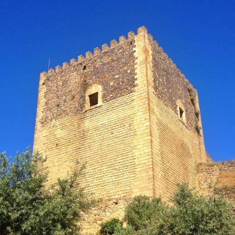 A historic stone tower with crenellations and two small windows.