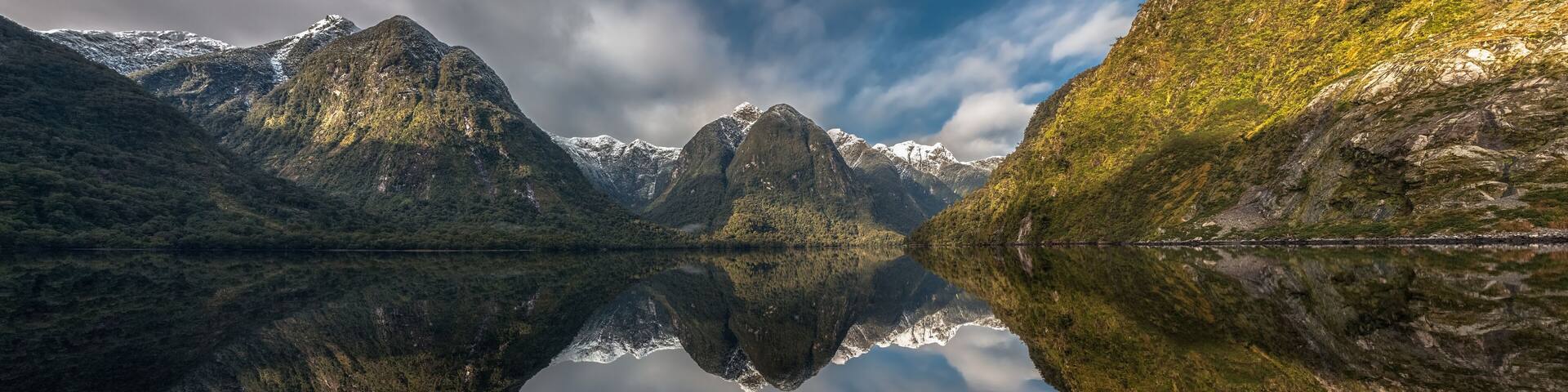 Panoramic view of Doubtful Sound, New Zealand, seen over the tip of a canoe in the foreground