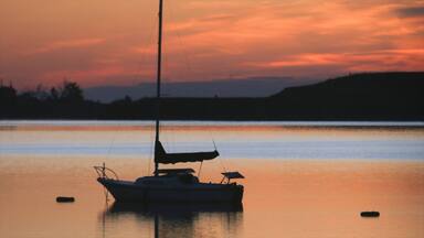 Boulder showing boating, a lake or waterhole and a sunset