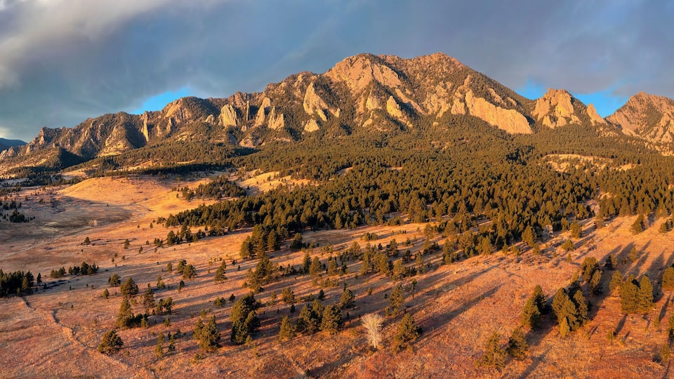 A mountainous landscape with dense forests and rocky peaks.