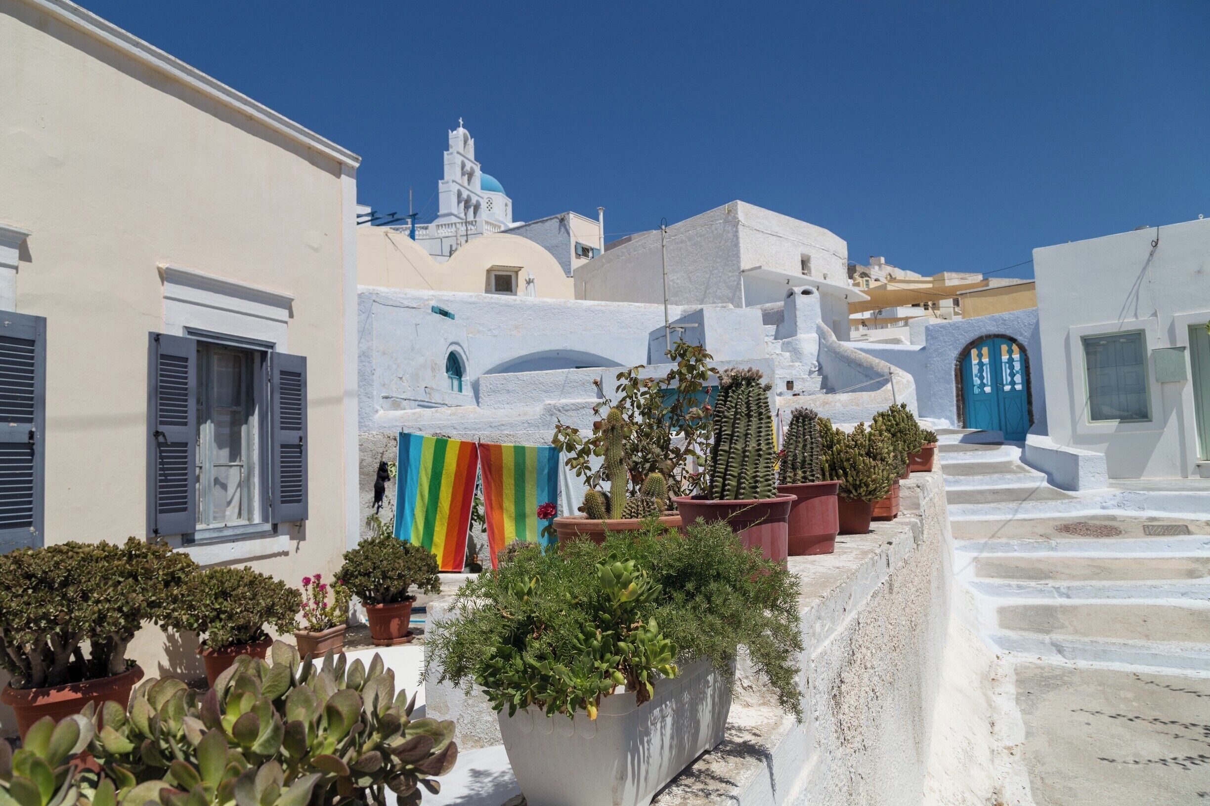 If you find yourself on the Greek island of Santorini and want to escape the crowds of tourists, I would highly recommend you try the small village of Pyrgos.
It is actually not that small, and if, like me, you stop at every corner to get a photo, you will spend a good half day there.  So many opportunities in the narrow streets, with white walls and houses, coloured features everywhere, a couple of churches and historical buildings, and an amazing view all the way to the Asean sea.