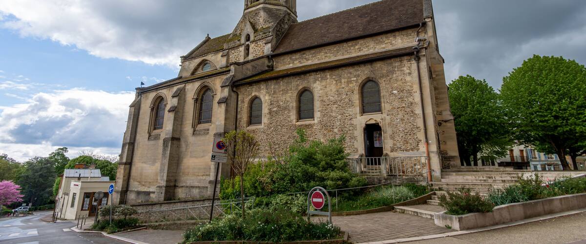 A historic church with a tall steeple and arched windows.