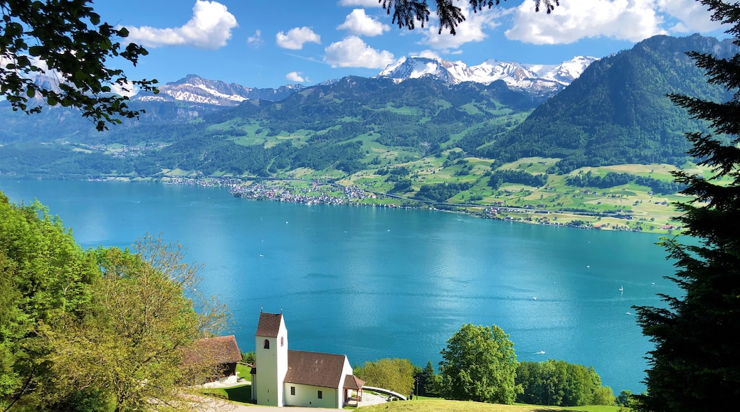 A lake surrounded by mountains, a small church, and a village.