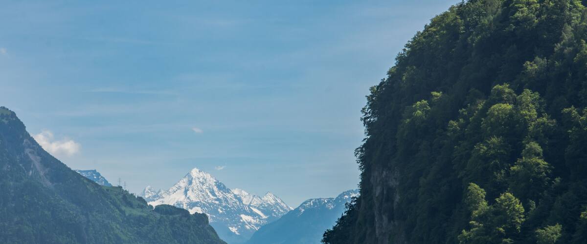 A lake surrounded by mountains with snow-capped peaks in the background.
