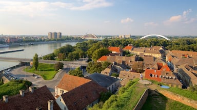 Un pueblo a orillas del río con edificios históricos, un puente y un puente moderno de arco.