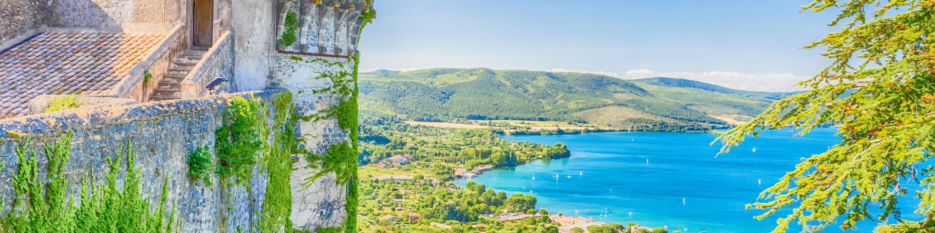 Un pueblo costero con una torre histórica, abundante vegetación y una vista despejada del mar.