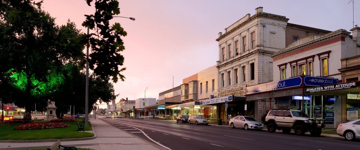 A street lined with shops and a building with a sign reading "Cruiseabout".
