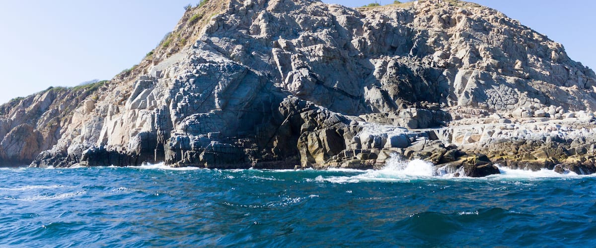 A rocky coastline with a lighthouse on top.