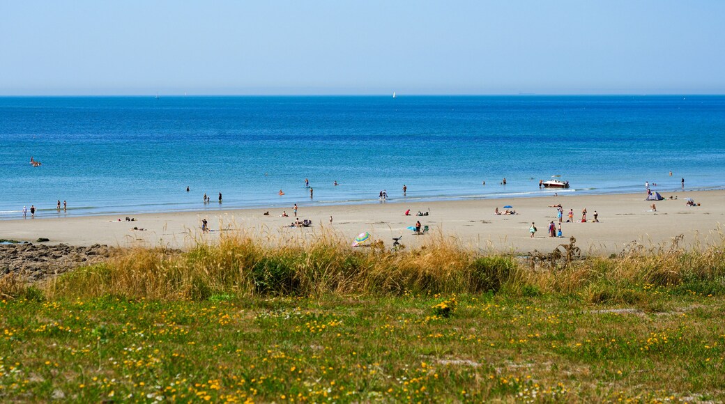 A beach with people, boats, and a clear blue sky.