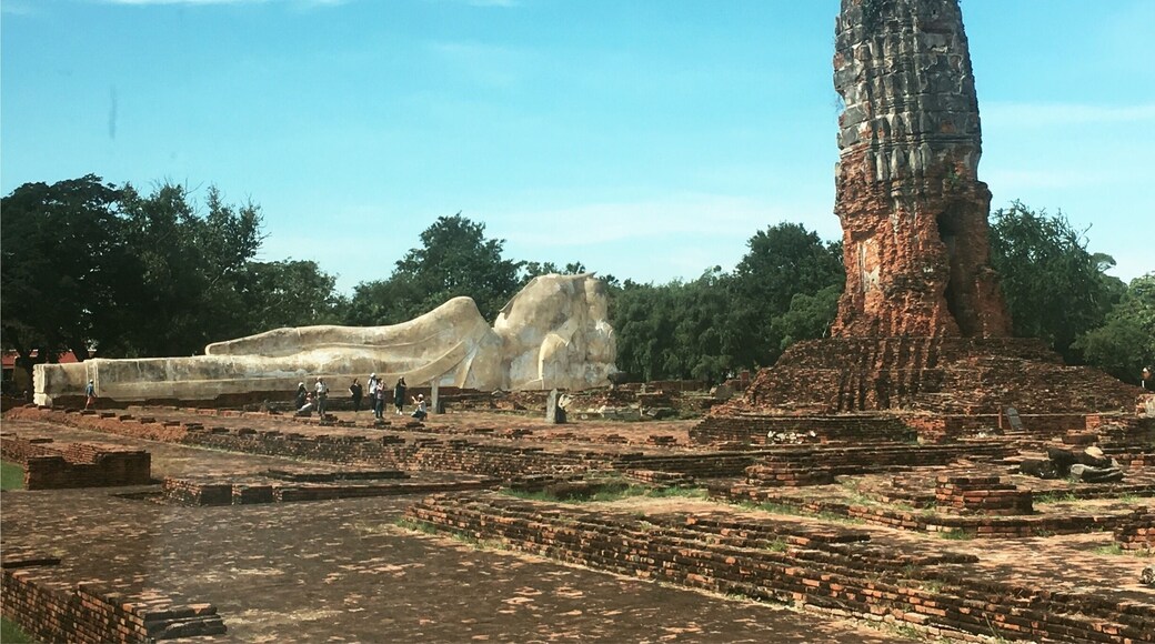 The reclining Buddha is 42 meters in
length and 8 meters high, and its name is Phra Buddha Sai Yat. The reclining Buddha
image is aligned to a north/south axis, and it is facing west. All the Buddha’s toes are of
equal lengths. The arm supporting the head is vertical, instead of being folded as in the
Early Ayutthaya and U-Thong periods. This vertical arm is a characteristic of reclining
images made in the Middle Ayutthaya period - after the 16th century (Amatyakul 47).
The reclining Buddha image is usually wrapped in brightly colored orange cloth. A small
altar exists beside it where visitors can make offerings. Many people have covered
portions of the image in gold leaf.