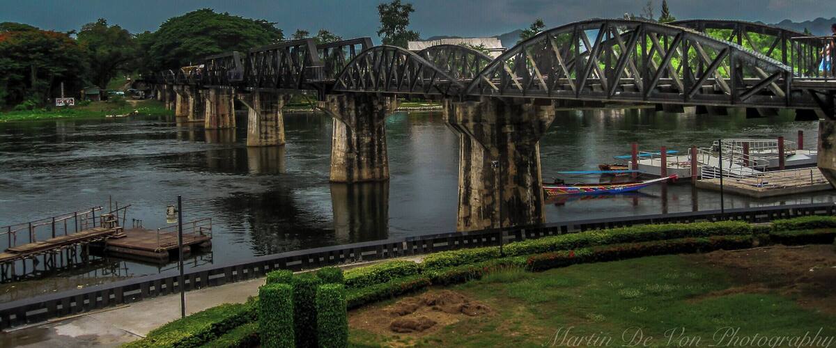 During World War 2, the Japanese used Allied prisoners of war to build a railway from Thailand to Burma so they could supply their army without the dangers of sending supplies by sea.  Many prisoners died under appalling conditions during its construction, and the line became known as the 'Death Railway'.  It was immortalised in David Lean's 1957 film 'The Bridge on the River Kwai' which centres around one of the line's main engineering feats, the bridge across the Kwae Yai river just north of Kanchanaburi.  Although the film was shot in Sri Lanka, the Bridge on the River Kwai really exists, and still carries regular passenger trains from Bangkok as far as Nam Tok.  For anyone interested in 20th century history, a visit to Kanchanaburi and the infamous Death Railway is a must.
This page gives all the necessary information for train travel from Bangkok to Kanchanaburi, the Bridge on the River Kwai & Nam Tok, along with an overview of what there is to see in the area, including the Bridge Over the River Kwai, the Wampo (Wang Po) Viaduct and the museum at Hellfire Pass (Konyu Cutting).  You can see the Bridge on the River Kwai as a day trip from Bangkok using the morning train out and afternoon train back, but it's better to make it a 2 or 3 day trip as there's a lot more to see than just the Bridge.  For example, you could take the morning passenger train from Bangkok to Kanchanaburi on day 1, stay a night or two in Kanchanaburi, then take the afternoon train back on day 2 or 3, so you can visit Hellfire Pass (less well known than the Bridge, but not be missed) and travel the Death Railway through fantastic scenery over the dramatic Wampo Viaduct as far as its current terminus at Nam Tok.
