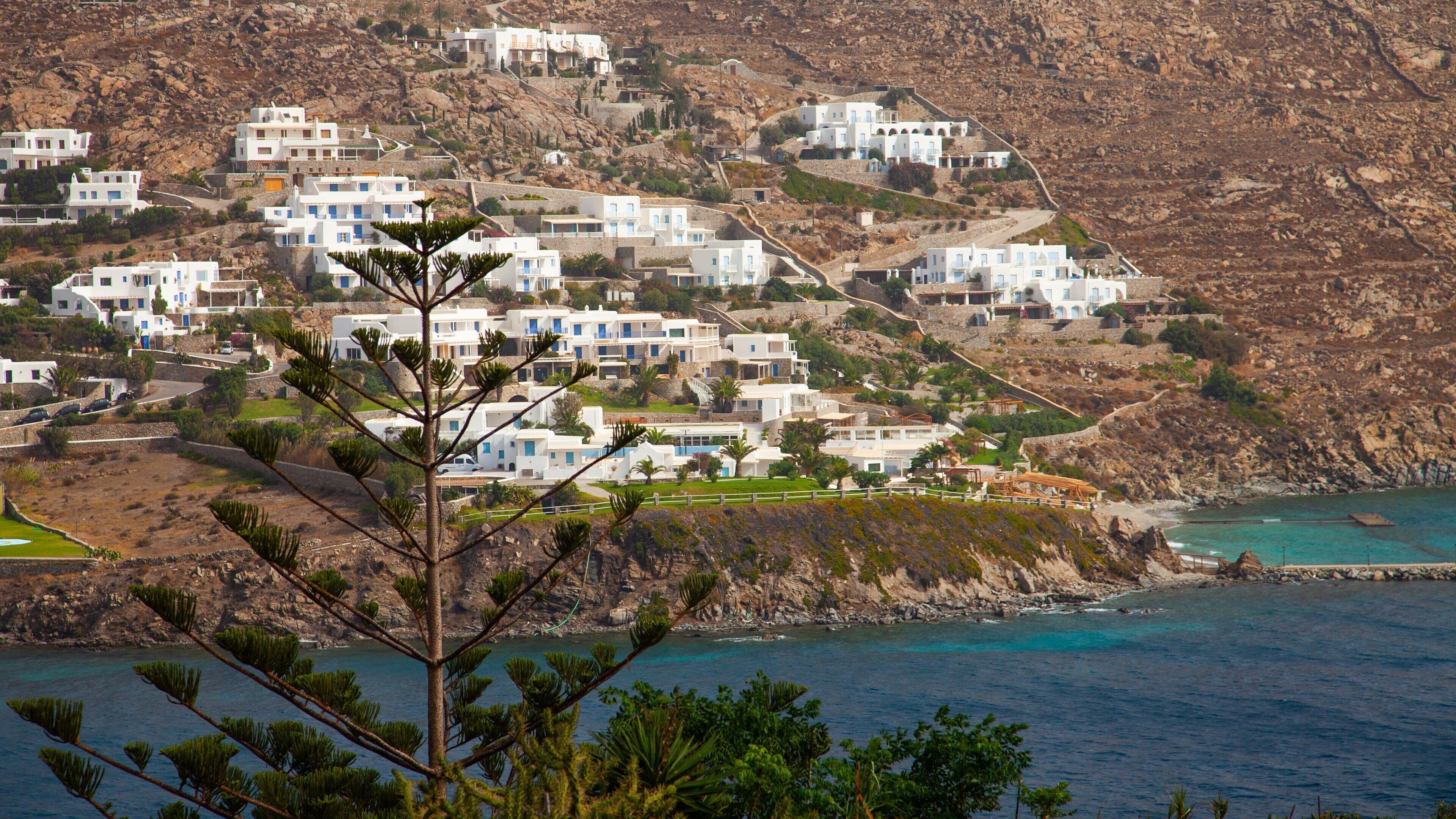 Un pueblo costero con edificios blancos en una colina con vistas al mar.