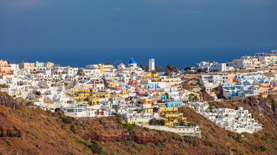 A coastal town with colorful buildings, a prominent church, and a clear view of the sea.