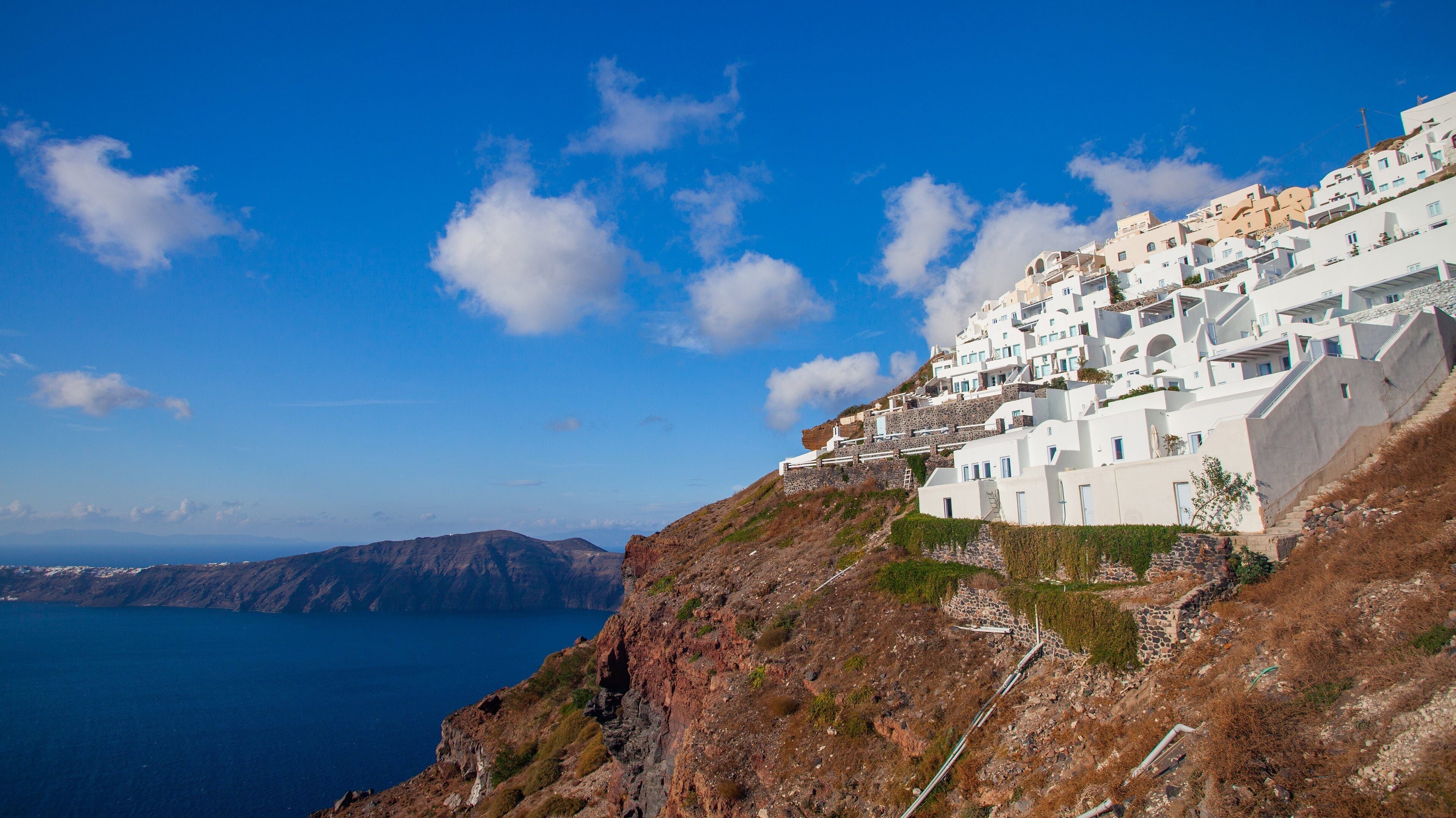 A coastal village with white buildings on a hillside overlooking the sea.