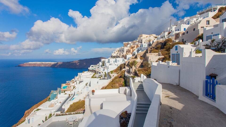 A coastal village with white buildings and a clear blue sea.