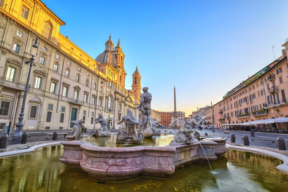 A historic fountain with sculptures in a city square.