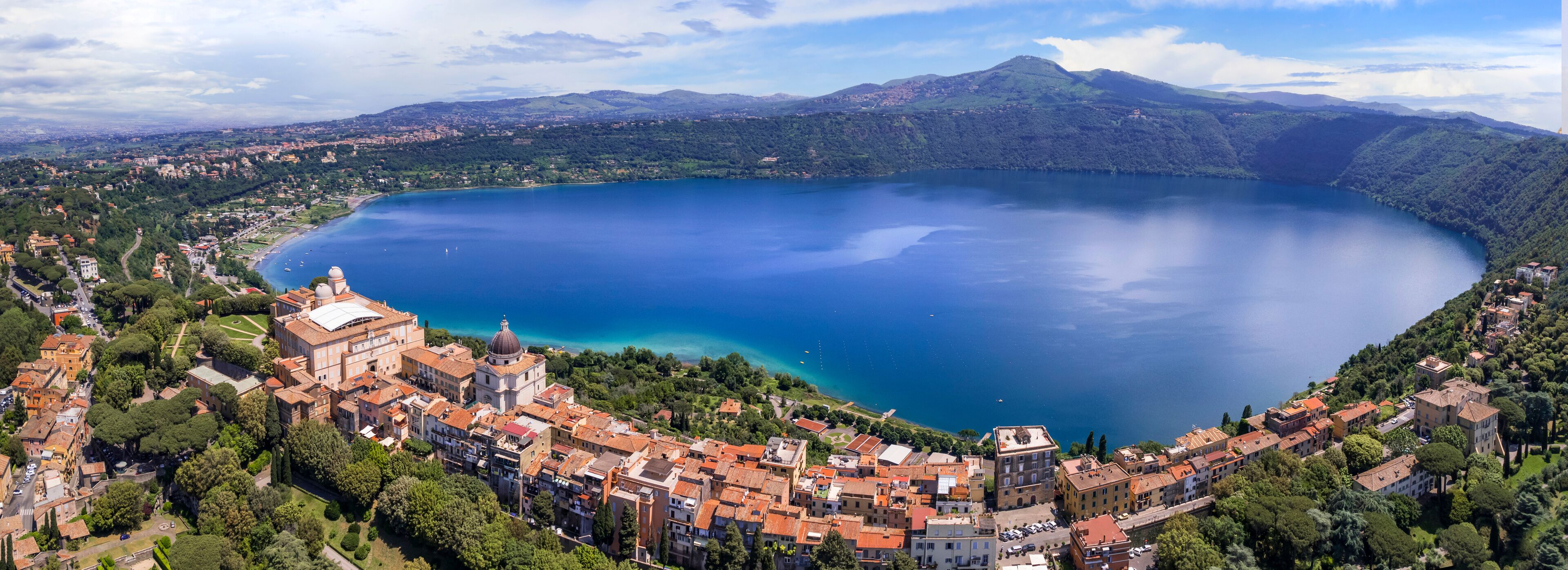 A coastal town with a large lake, historic buildings, and surrounding hills.