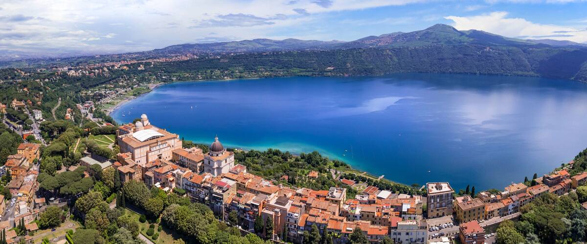 A coastal town with a large lake, historic buildings, and surrounding hills.
