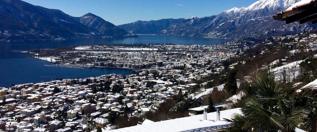 A mountainous landscape with a town in the foreground and a lake in the background.