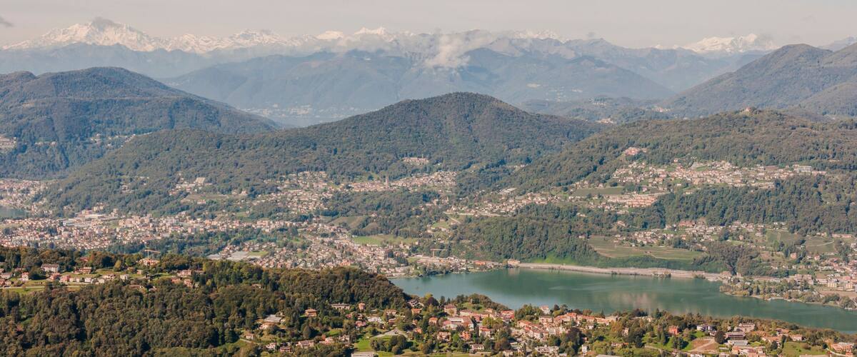 A mountainous landscape with a town and a lake.
