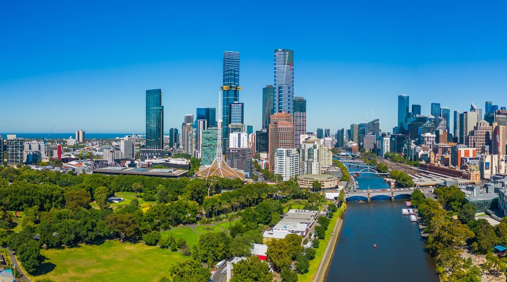 A city skyline with modern skyscrapers, a river, and green spaces.