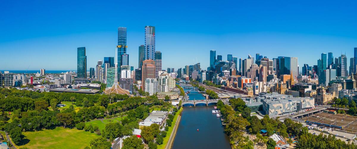 A city skyline with modern skyscrapers, a river, and green spaces.