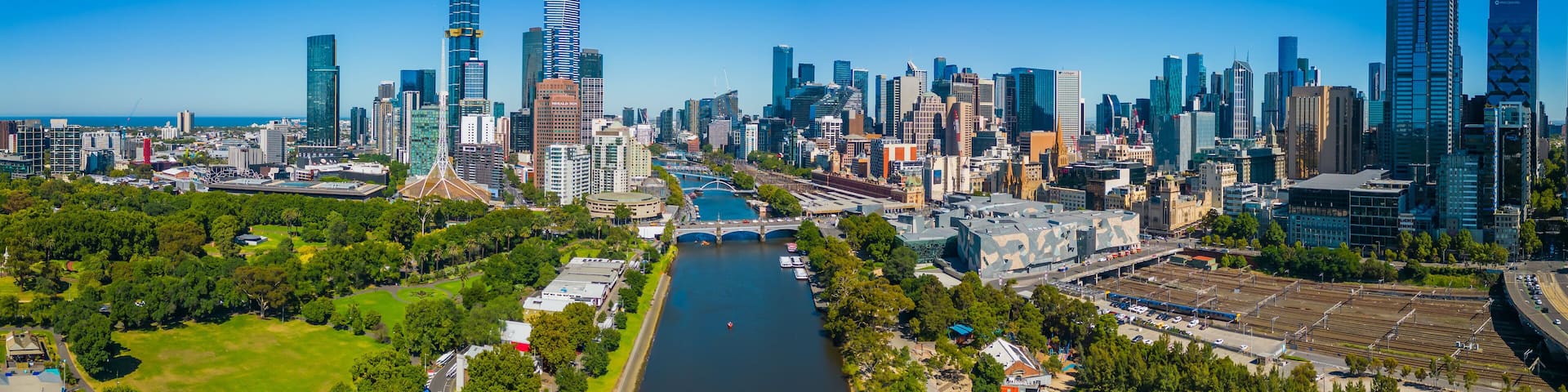 A city skyline with modern skyscrapers, a river, and green spaces.