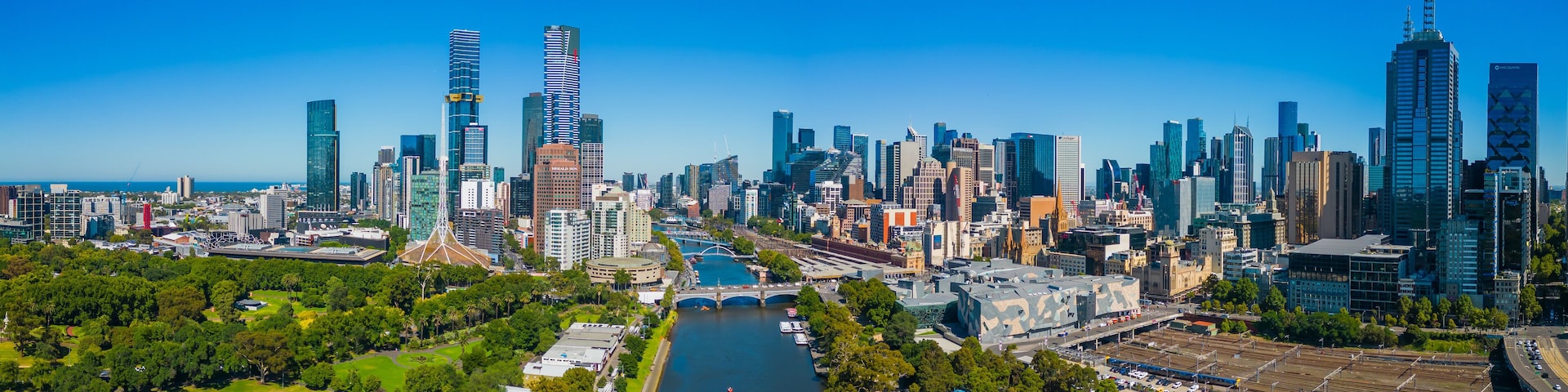 A city skyline with modern skyscrapers, a river, and green spaces.