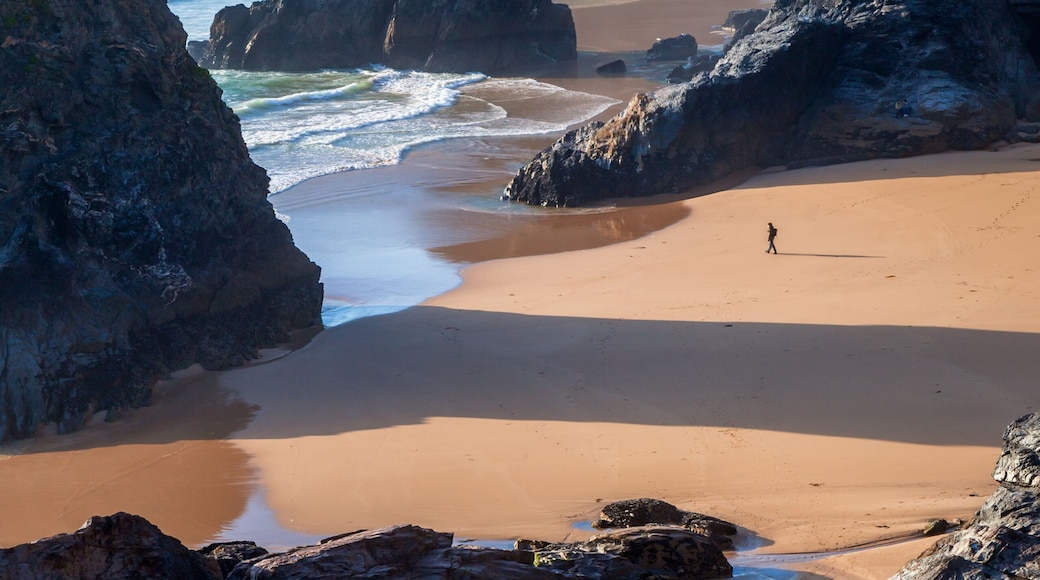 Bedruthan Steps and beach at low tide on the North Cornwall coast, with the late afternoon summer sun casting long shadows.