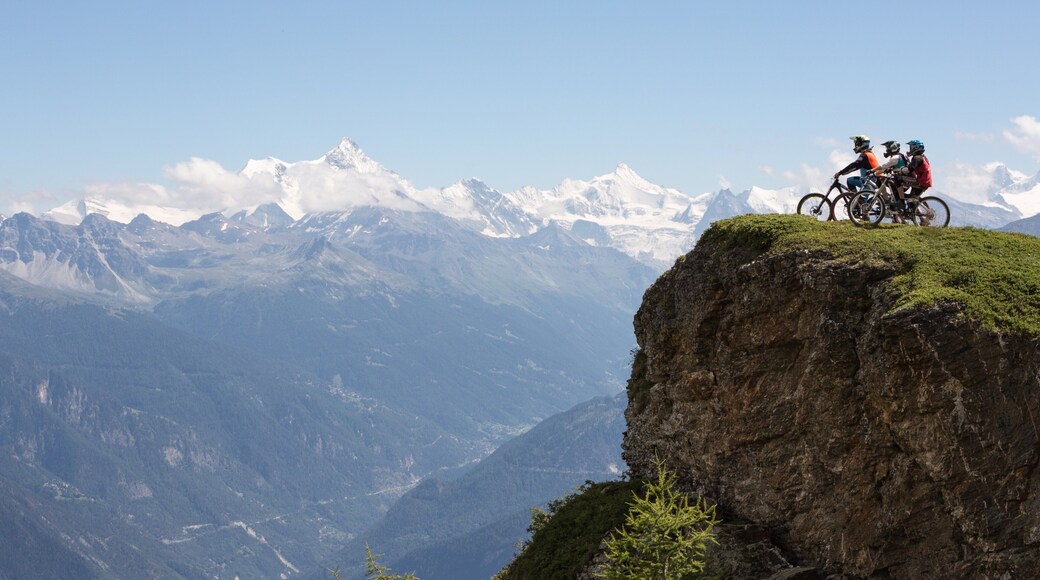 Crans-Montana Ski Resort showing mountains and mountain biking as well as a small group of people