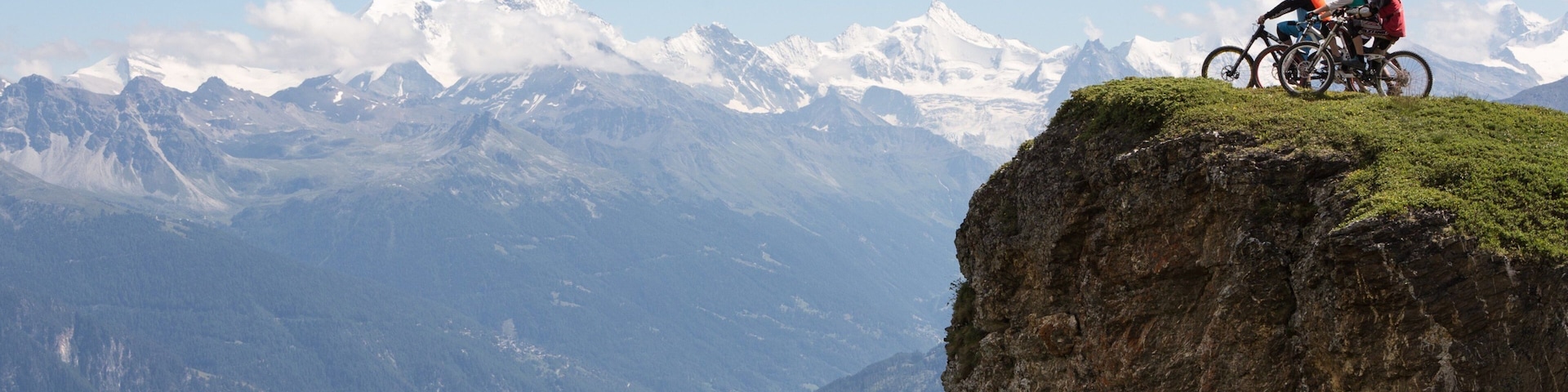 Crans-Montana Ski Resort showing mountains and mountain biking as well as a small group of people