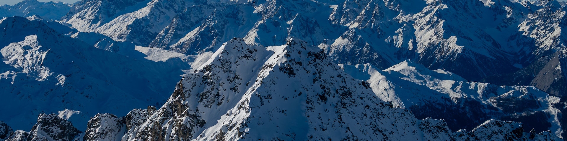 Montañas nevadas bajo un cielo azul despejado.