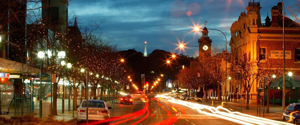 A city street at night with streetlights, a clock tower, and a building labeled "Albury Regional Art Centre".