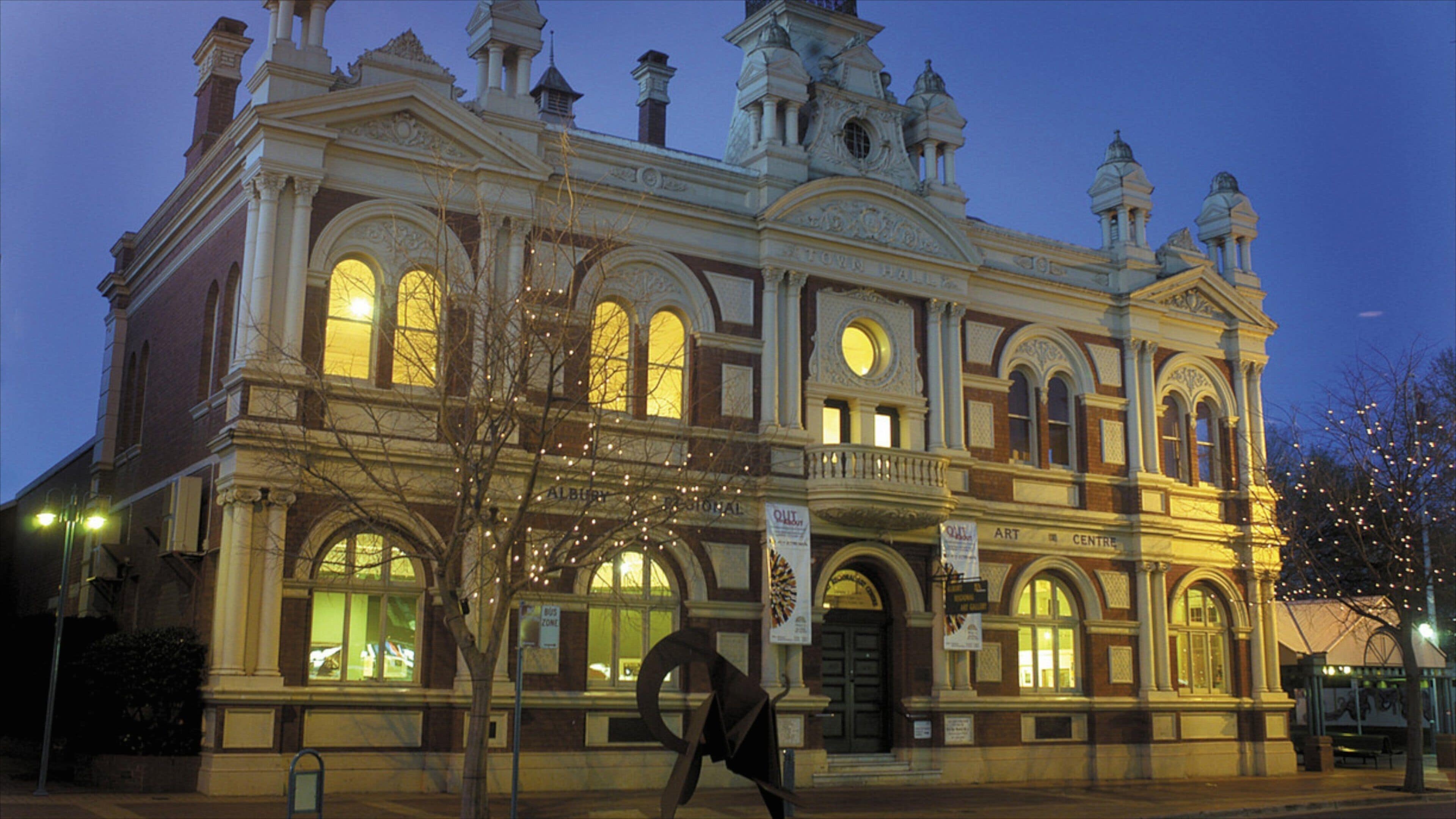 A historic building with ornate architecture, large arched windows, and a prominent clock tower.