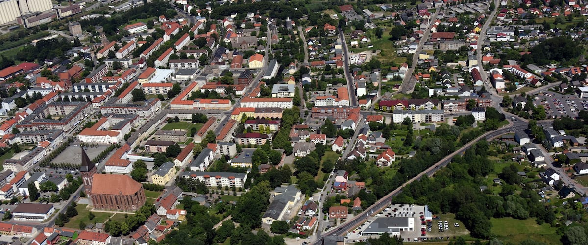 An aerial view of a town with dense housing, a prominent church, and a highway.